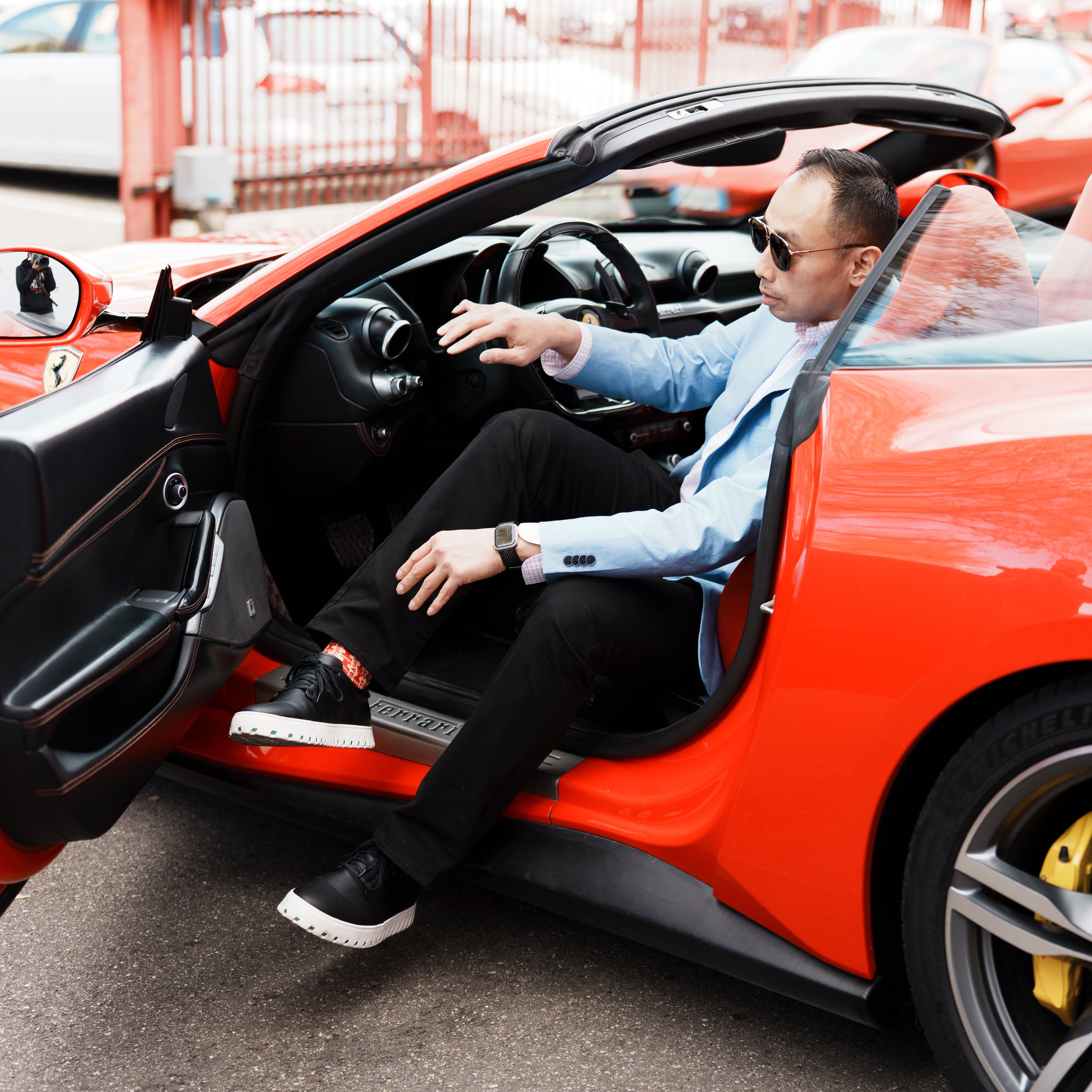 Man getting into a red sports car with IAMBIC MODEL T shoes